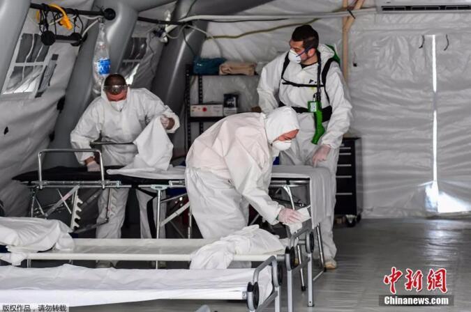 在意大利米兰东南部克雷莫纳,身着防护服的清洁人员正在为收治新冠状肺炎患者的野战医院帐篷内消毒。 在意大利米兰东南部克雷莫纳,身着防护服的清洁人员正在为收治新冠状肺炎患者的野战医院帐篷内消毒。