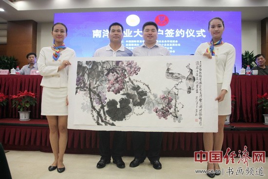 著名国画家李泽存(左)赠送国画表示祝贺,贵州茅台镇南洋酒业有限公司总经理蔡峰(右)代为接收。